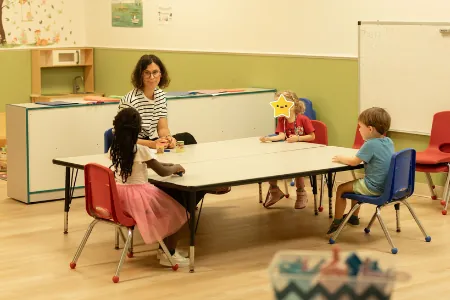 Children doing activities at tables with their teacher