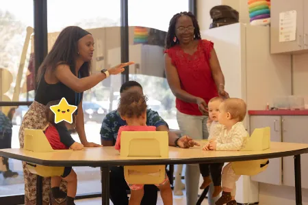 Teachers with toddlers at a classroom table
