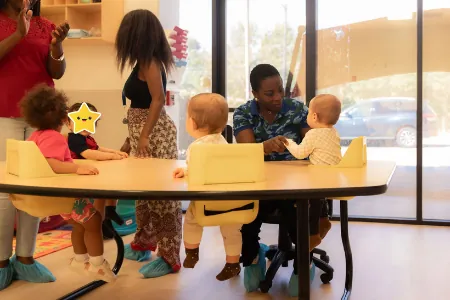 Teachers with toddlers at a classroom table