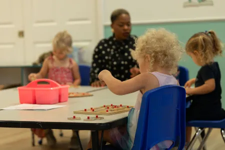 Teacher with children doing an activity at a table