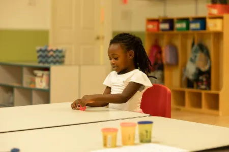 Child painting at a classroom table