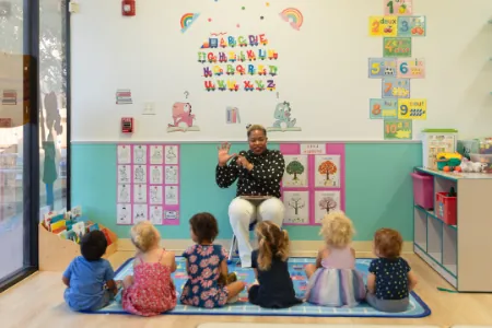 Teacher leading circle time with children on the classroom rug