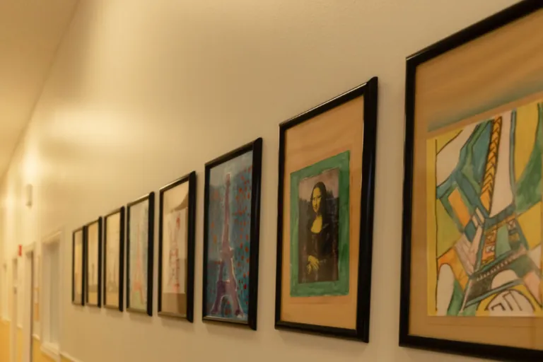 Hallway lined with framed children's artwork