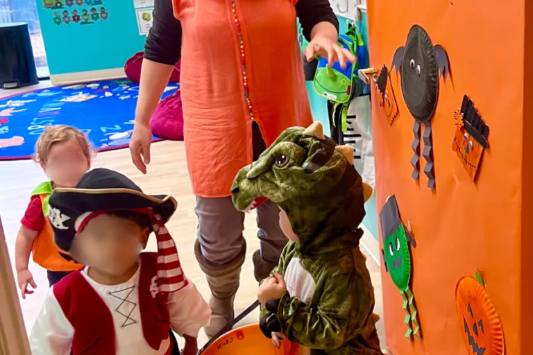 Children in costumes trick-or-treating in the classroom