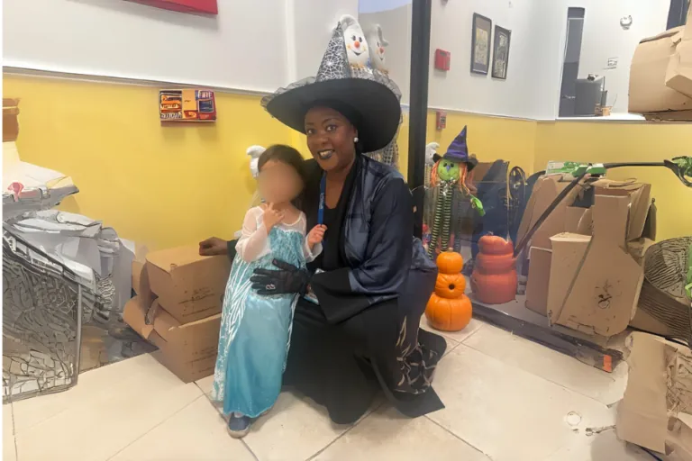 Teacher in a witch costume with a child for Halloween