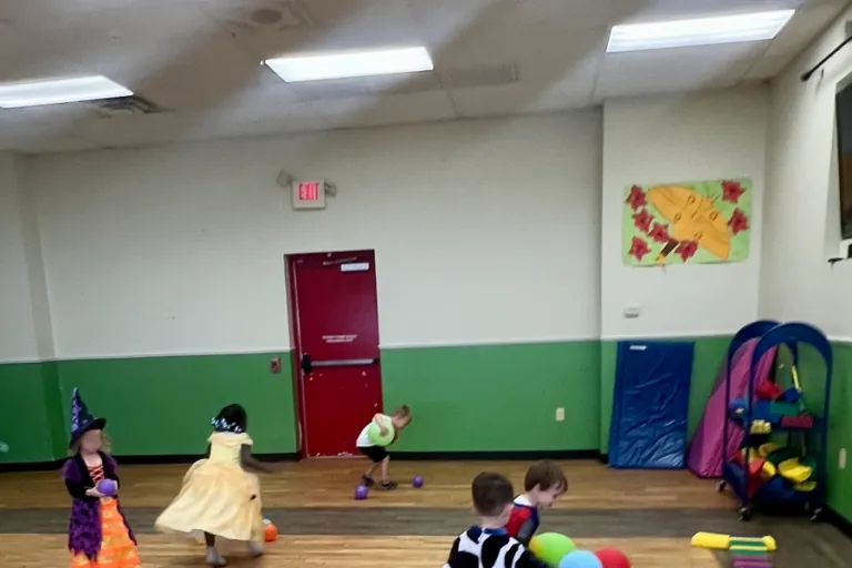 Children in costumes playing in the school hall