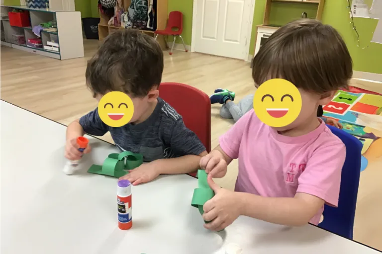 Two children playing with building toys at a table