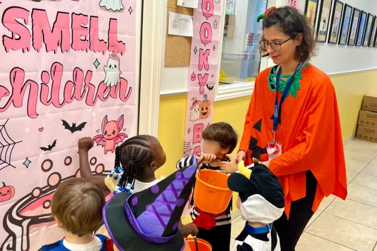 Teacher with children at a Halloween classroom display