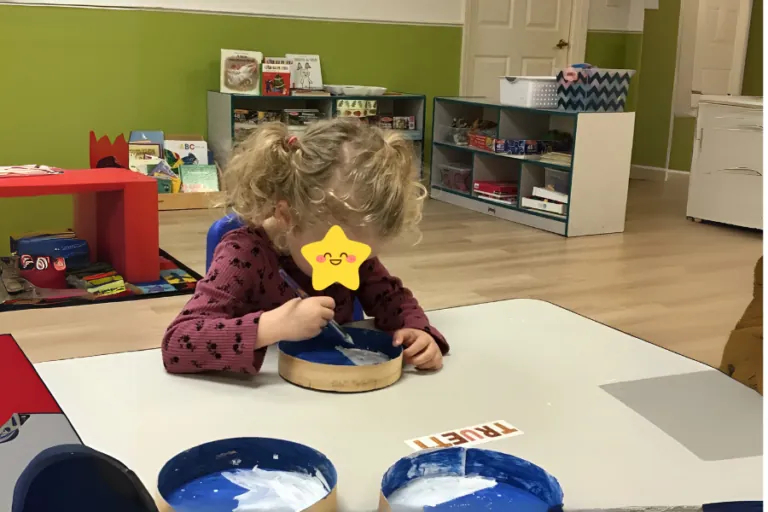 Child doing a hands-on activity at a classroom table