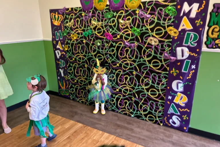 Children posing at the Mardi Gras photo wall