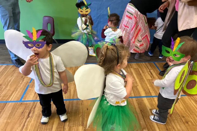 Children in costumes and masks celebrating Carnival at school